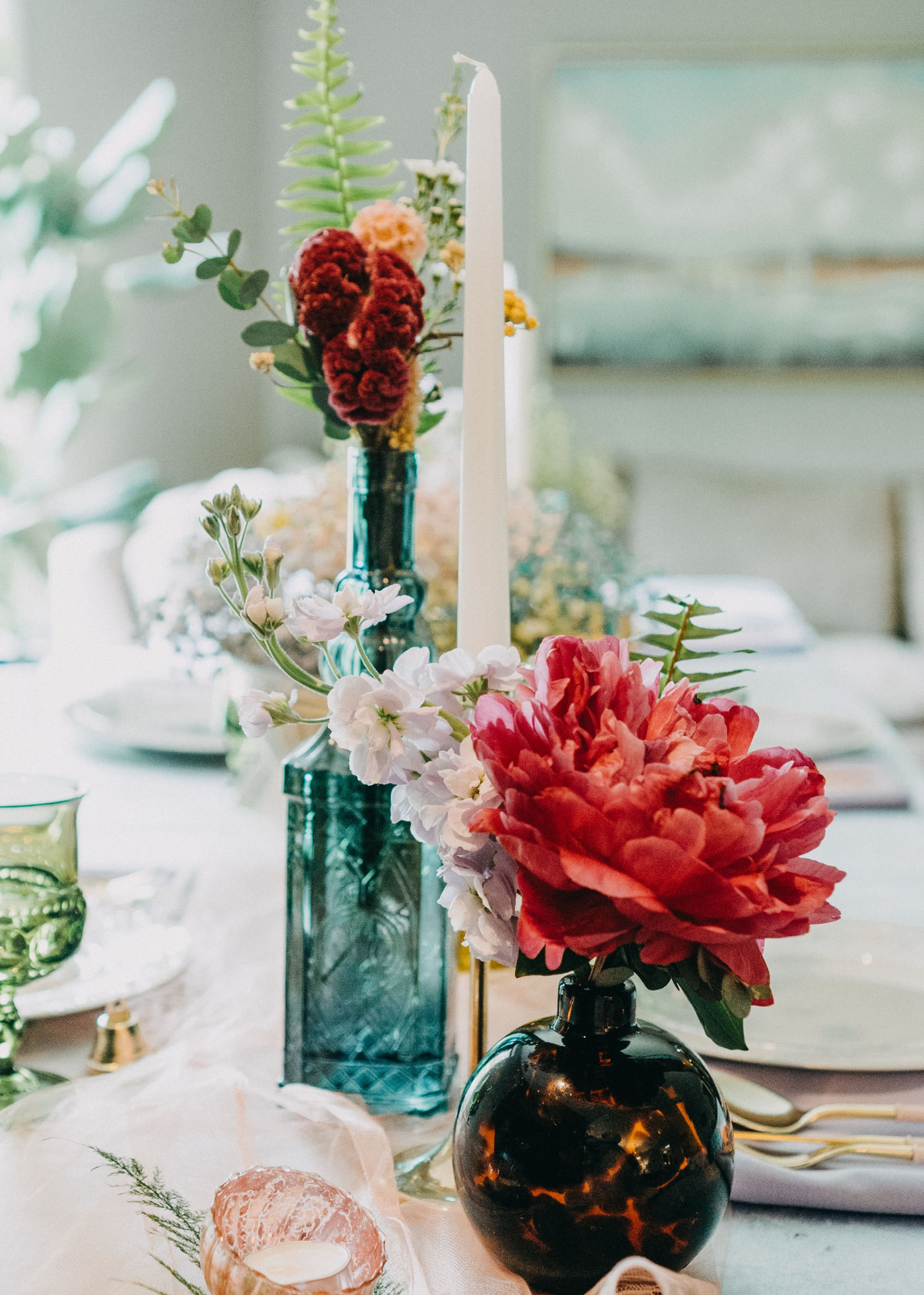 Vibrant floral centerpiece with taper candles at an elegant event table