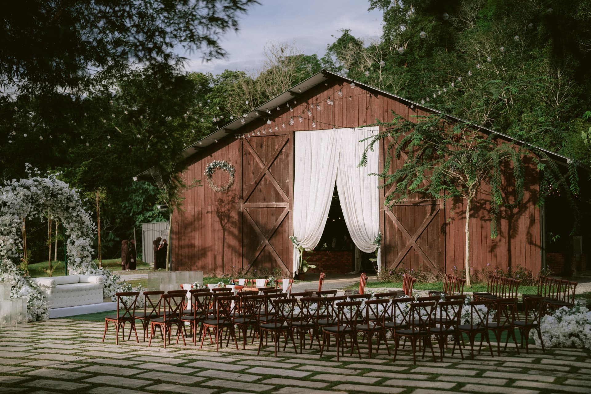 Outdoor barn ceremony with draped fabric and garden seating